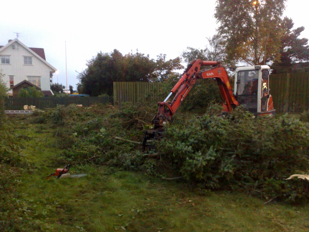 gravemaskin som rydder i hage