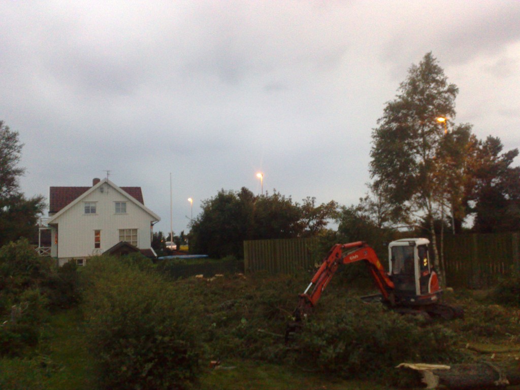 gravemaskin som rydder i hage