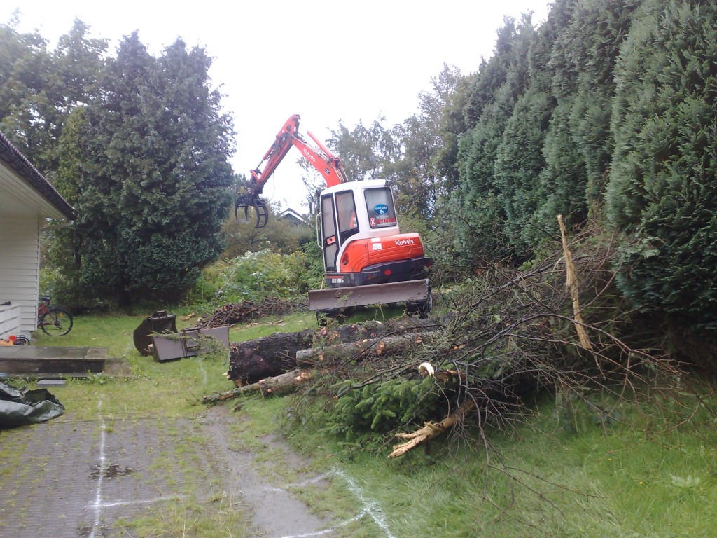 gravemaskin som rydder i hage